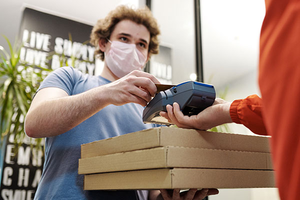 paying for pizza wearing masks